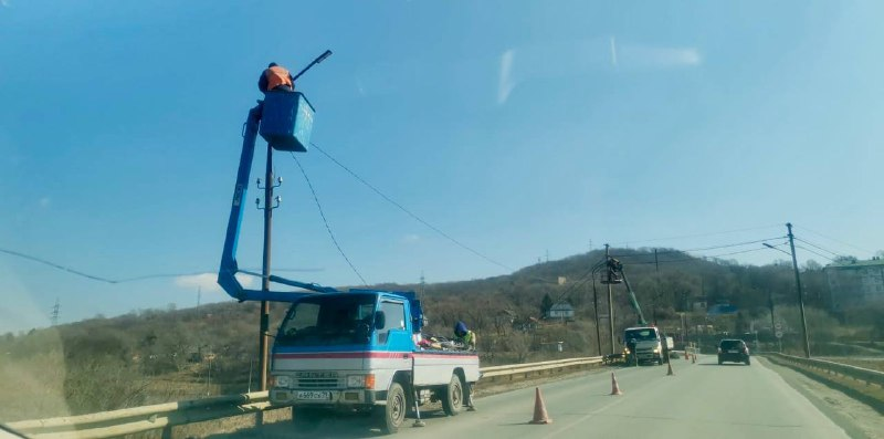 Подрядчик обустраивает освещение на мосту.